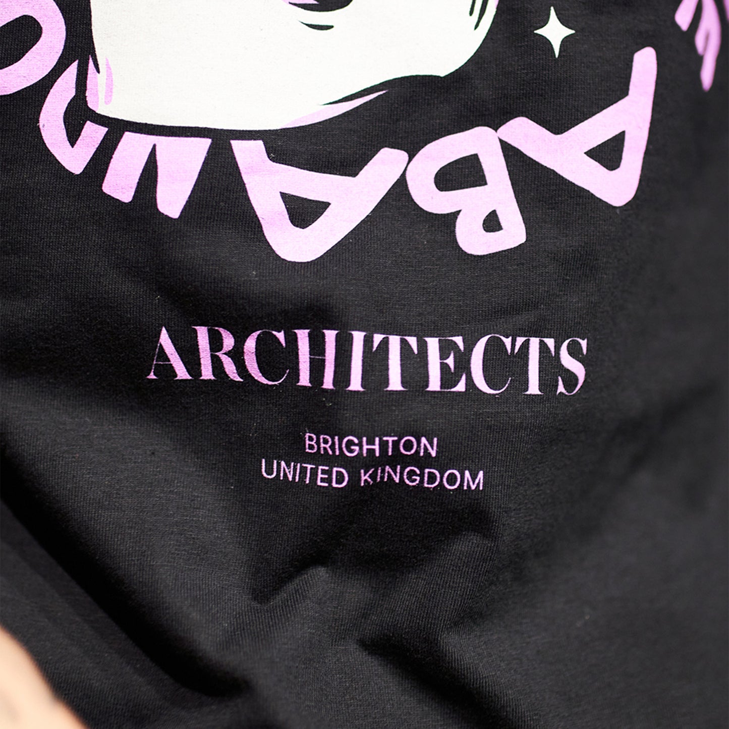 Black Children's short-sleeve t-shirt with pink Architects "All Our God Have Abandoned Us" skull print across the front