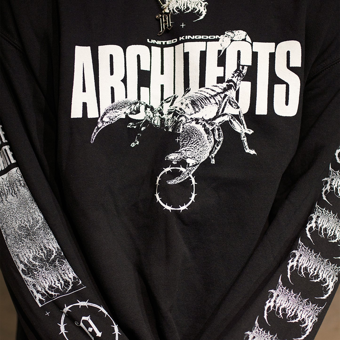 Black unisex crewneck featuring a white Architects Scorpio print across the front and a barbed wire print across the sleeves.