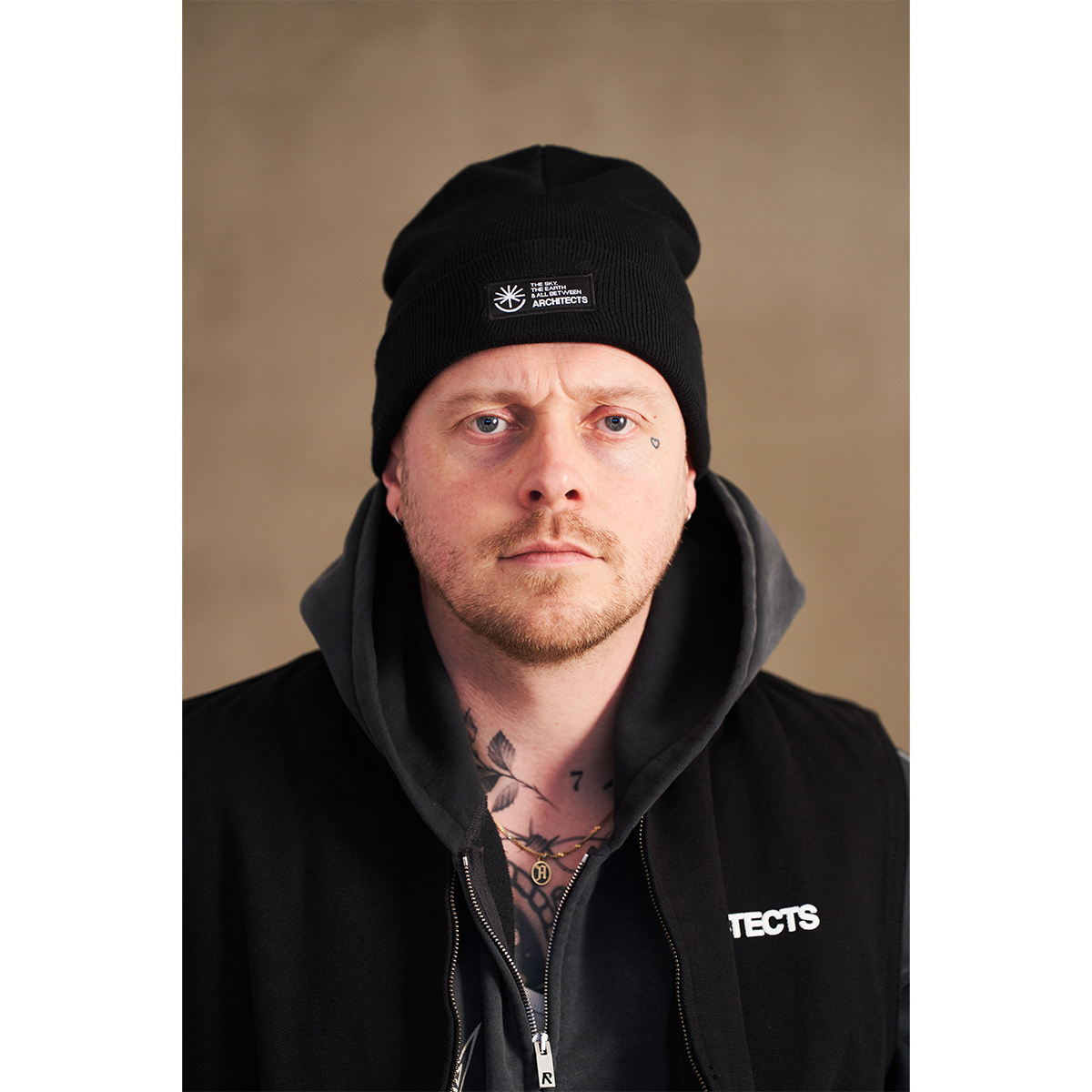 Black unisex Beanie with Architects The Sky, the Earth and All Between text patch across the front