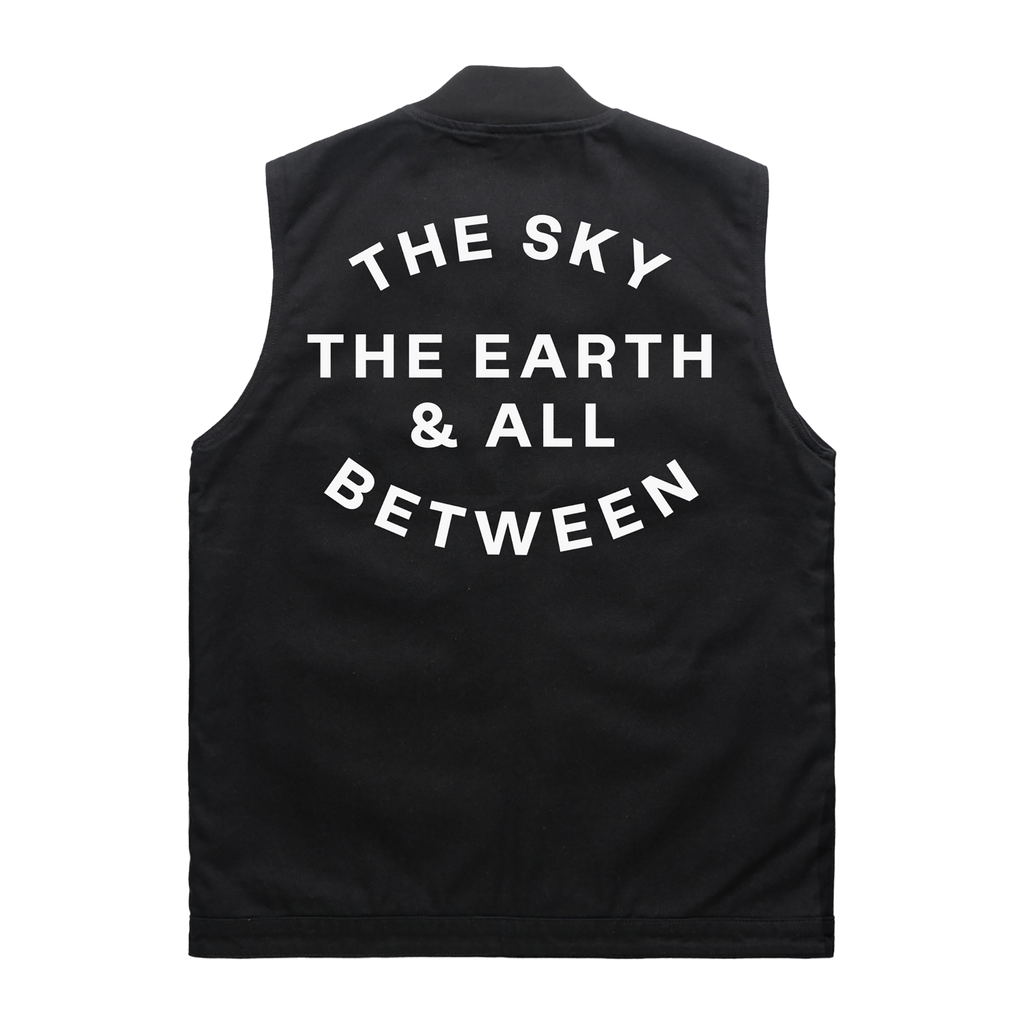 Black sleeveless canvas vest featuring white Architects The Sky, the Earth and All Between text print across the back.