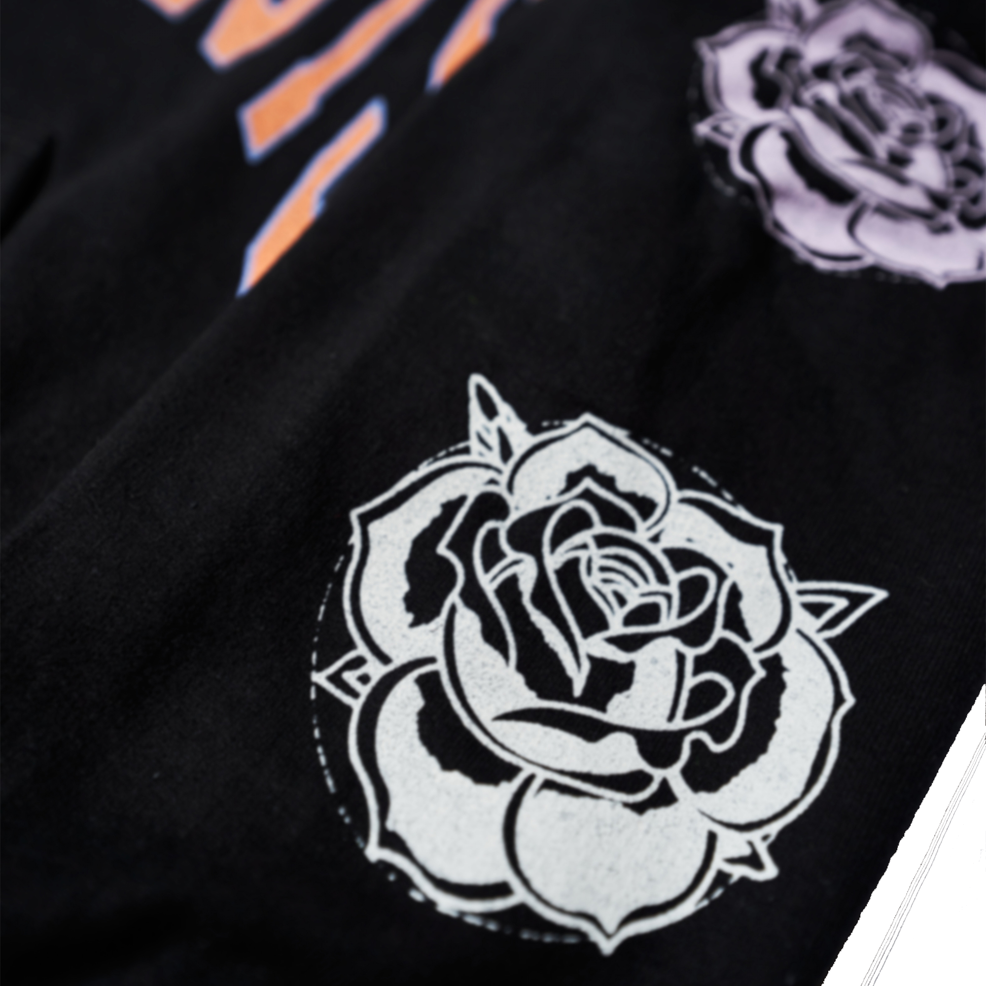 Black regular-fit unisex hoodie featuring an orange Architects print across the front, with blue, pink, and white rose prints along the sleeves.