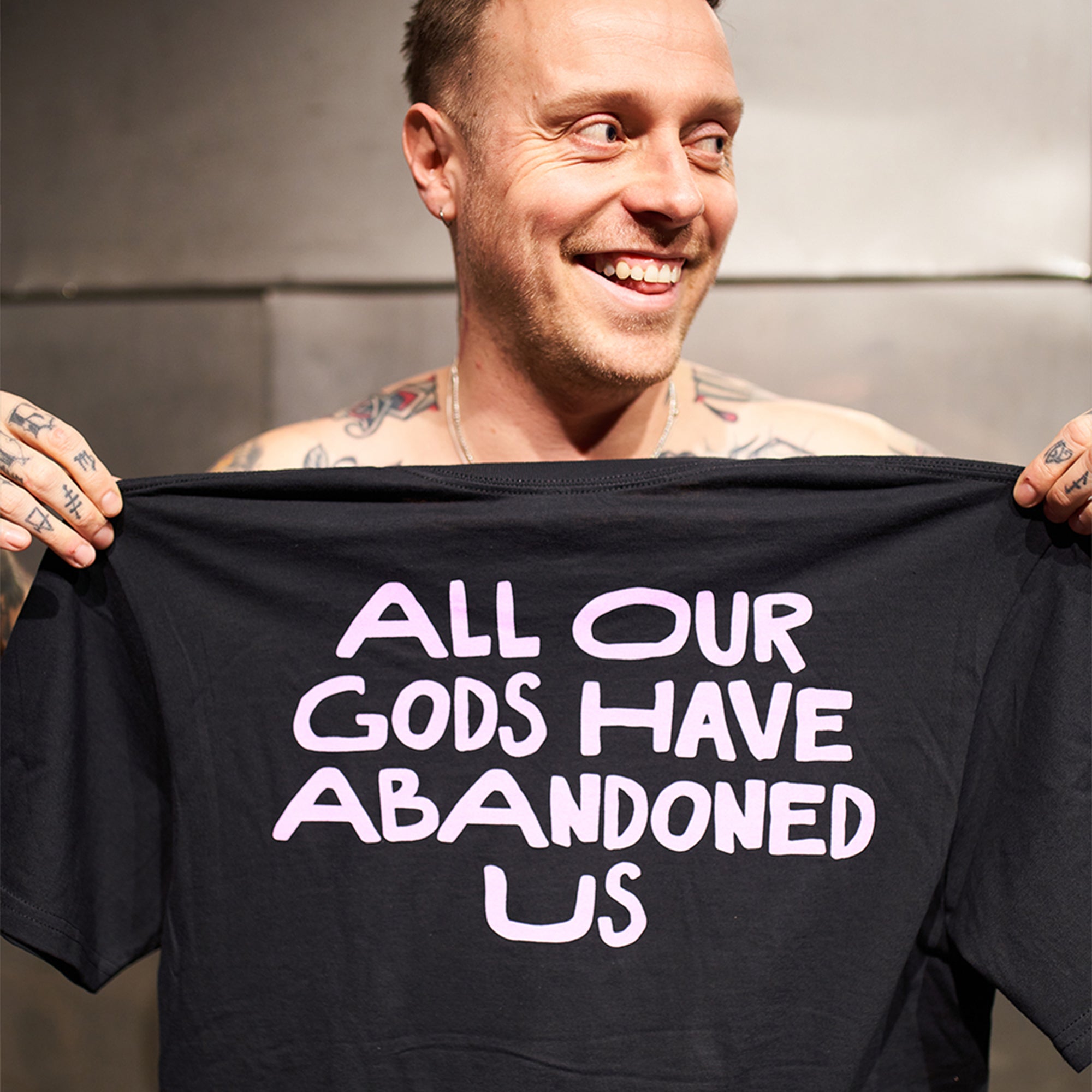 Black Unisex short-sleeve t-shirt with pink Architects "All Our God Have Abandoned Us" text print across the back