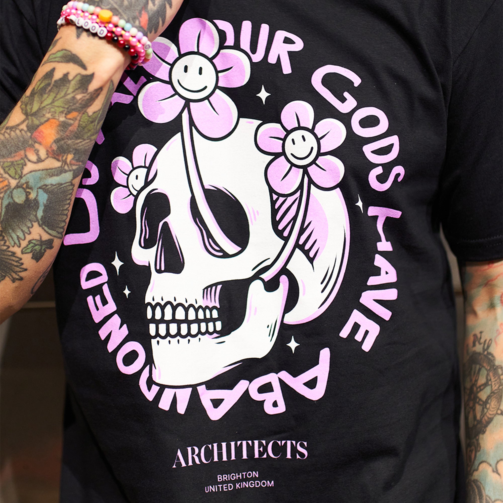 Black Unisex short-sleeve t-shirt with pink Architects "All Our God Have Abandoned Us" skull print across the front