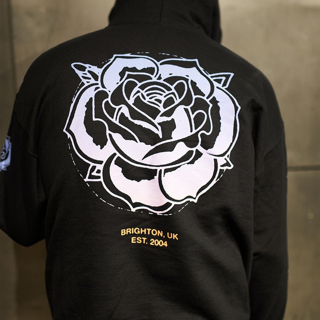 Black regular-fit unisex hoodie featuring a blue Architects rose print across the back, with blue, pink, and white rose prints along the sleeves.