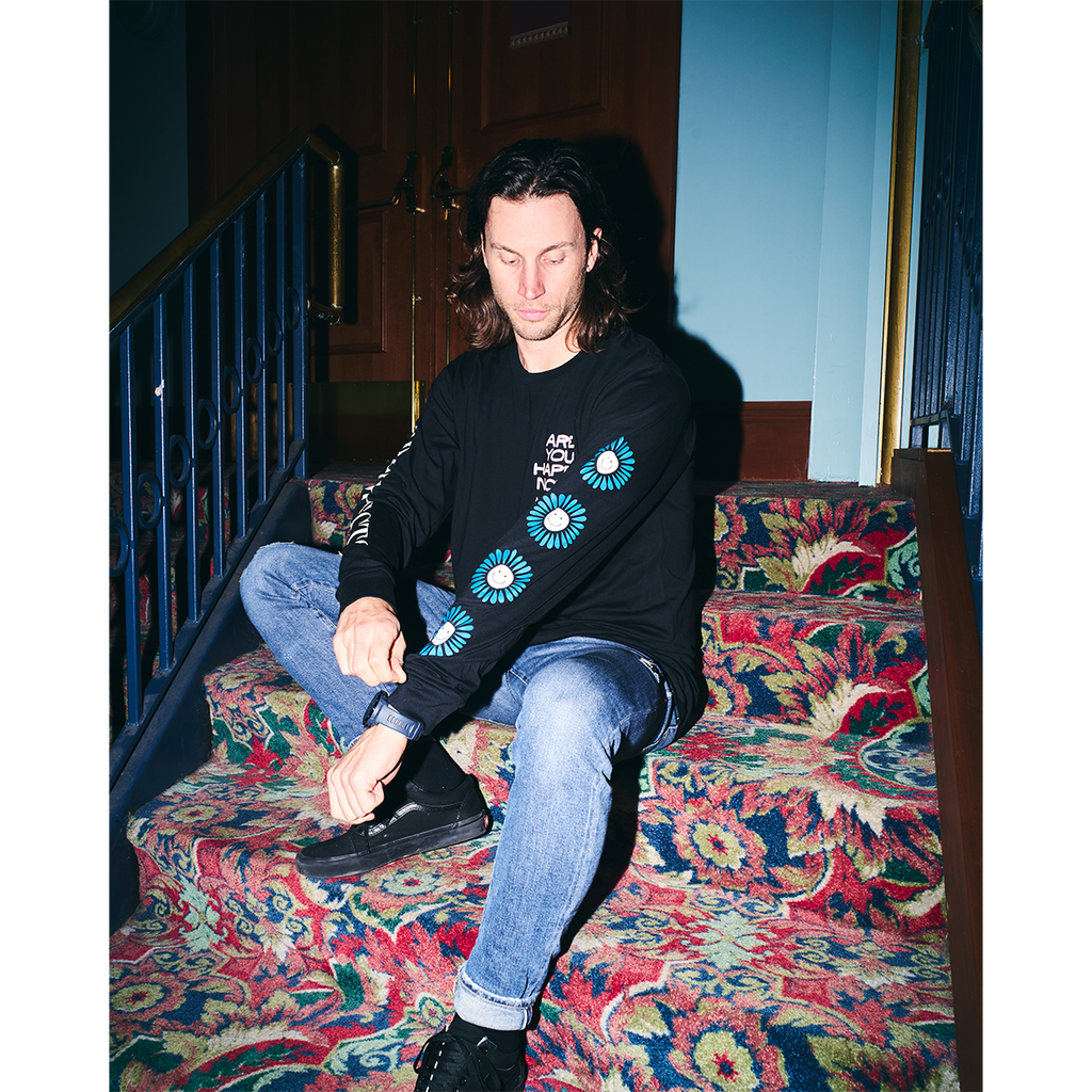 Black unisex long-sleeve T-shirt featuring a pink 'Are You Happy Now' print on the chest, with white and blue Architects prints along the sleeves.