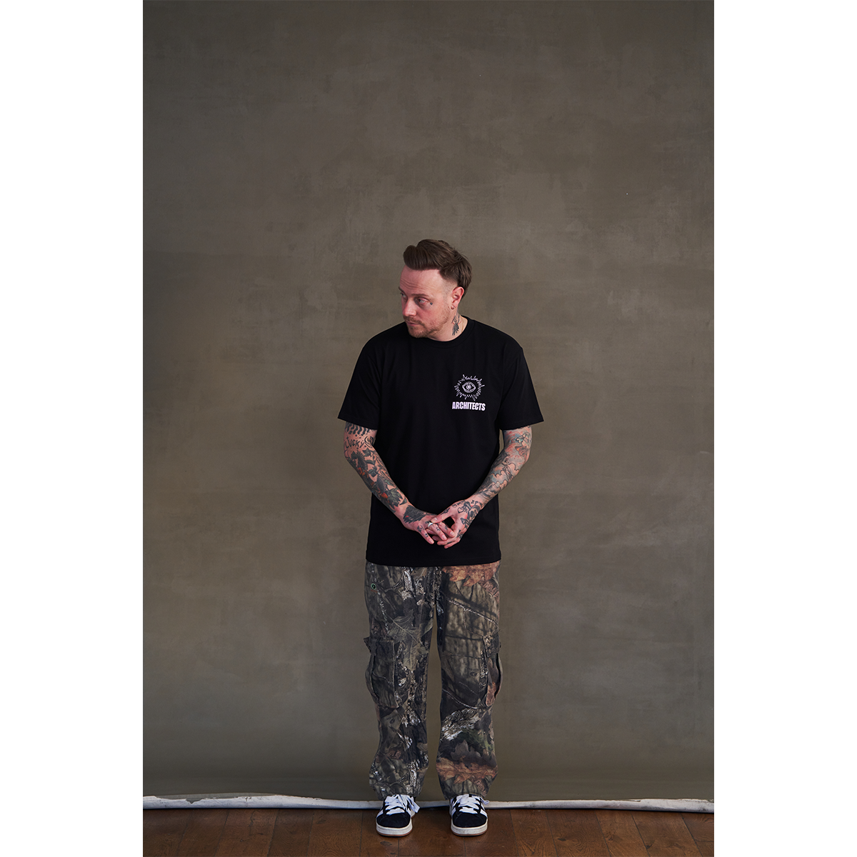 Black short-sleeve unisex regular fit T-shirt with round pink Architects eye print on the front chest