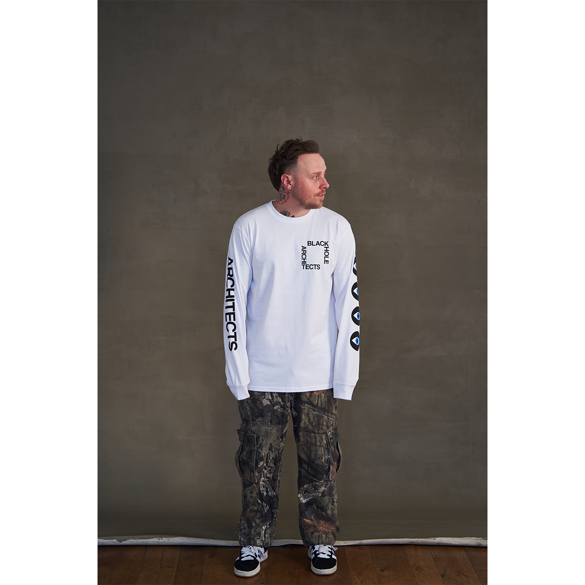 White long-sleeve unisex regular fit T-shirt with Architects Blackhole print on the front right chest, Architects text along the right sleeve, and eye print along the left sleeve.