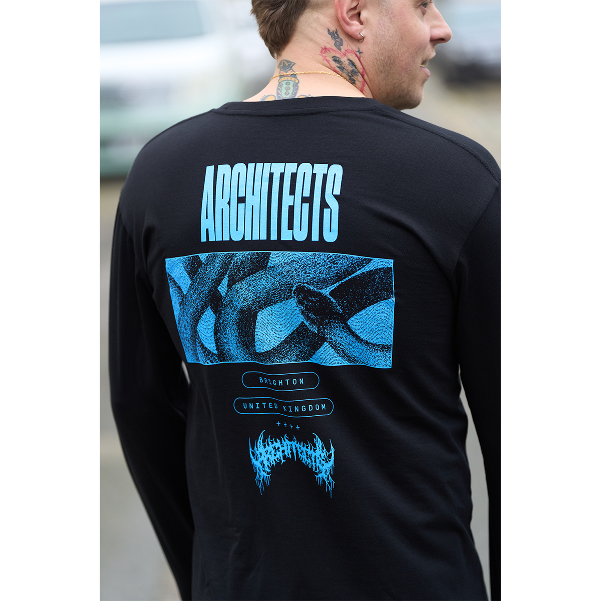 Black long-sleeve unisex regular-fit T-shirt featuring a blue Architects snake print across the back and a barbed wire print along the right sleeve.