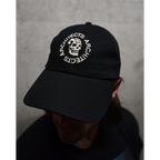 Person wearing a black cap with 'Architects' logo and skull embroidery