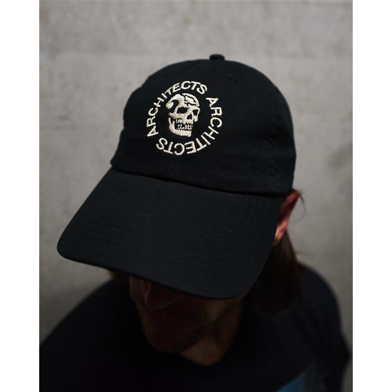 Person wearing a black cap with 'Architects' logo and skull embroidery